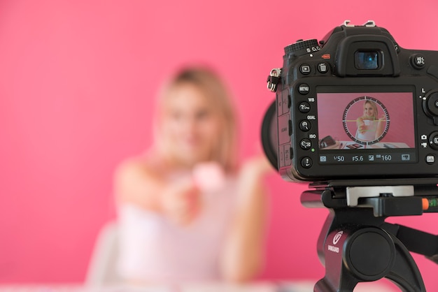 Foto influencer rubia grabando vídeo de maquillaje