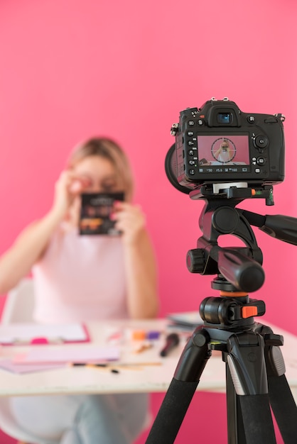 Foto influencer rubia grabando vídeo de maquillaje