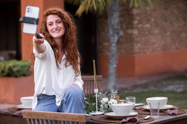 Foto influencer sonriente de plano medio con teléfono