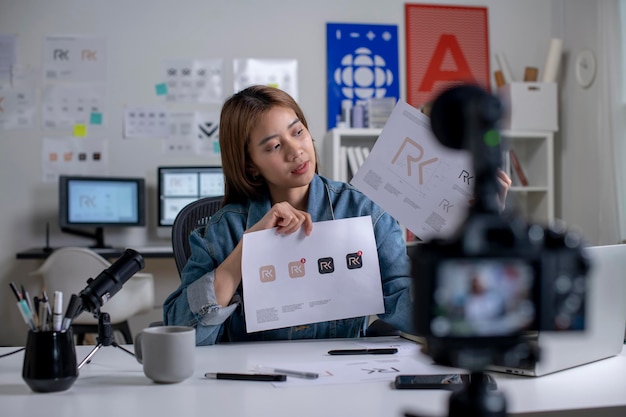 Foto influenciador de blogger de designer gráfico jovem asiática falando olhando para o tutorial de educação de tiro de câmera treinamento de vlog filmando curso de vídeo para mídia social no estúdio