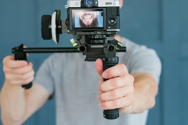 Influenciador de mídia social criando conteúdo homem gravando vídeo de si mesmo usando tecnologia moderna de câmera e conceito de trabalho freelance