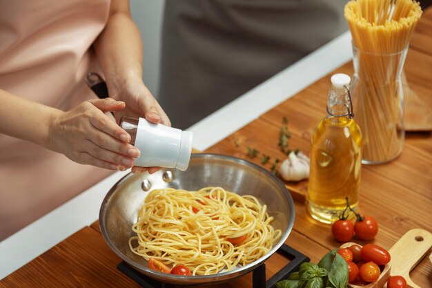 Foto influenciador de perto cozinhando mistura de espaguete ingrediente para frigideira postulado