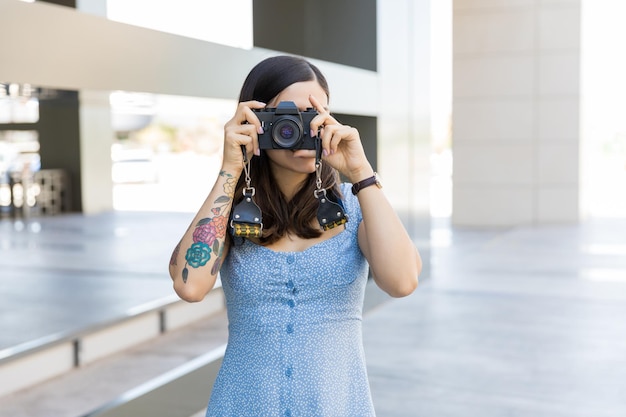 Influenciadora feminina fotografando com câmera no shopping