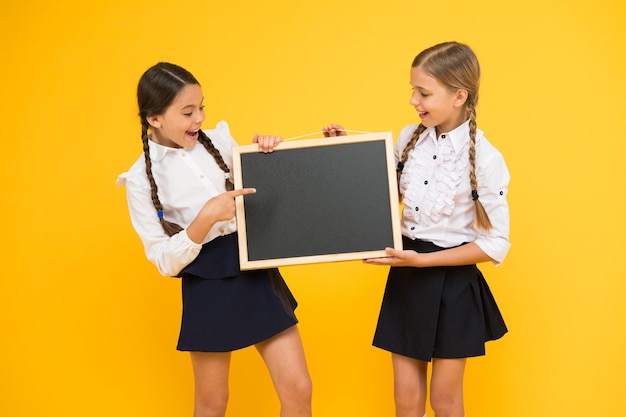 Informando cambios. Fondo amarillo del equipo de iniciativa de los compañeros de clase. Únete al club de la escuela. Comunidad de alumnos. Horario escolar. Las lindas alumnas de la escuela tienen espacio para copiar en la pizarra. Concepto de anuncio escolar.