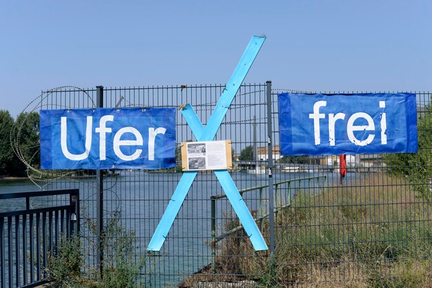 Informationsschild an einem Zaun gegen den blauen Himmel