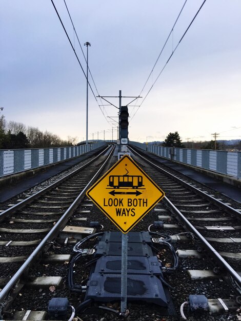 Informationsschild auf der Bahnstrecke gegen den Himmel