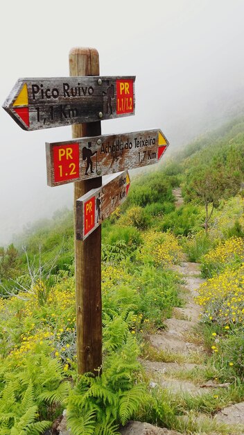 Foto informationsschild auf landschaft gegen himmel