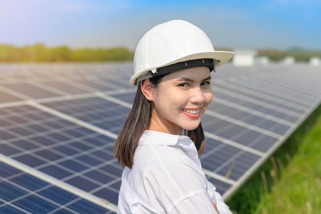 Una ingeniera con casco en una granja de células fotovoltaicas o en un campo de paneles solares