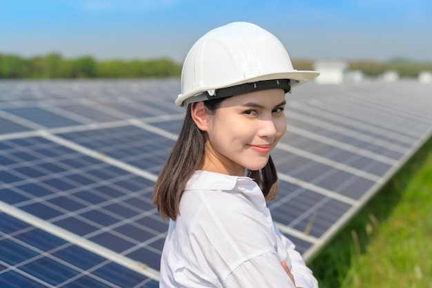 Una ingeniera con casco en una granja de células fotovoltaicas o en un campo de paneles solares