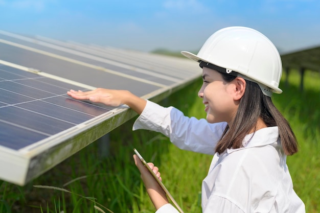 Una ingeniera con casco en granja de células fotovoltaicas o paneles solares