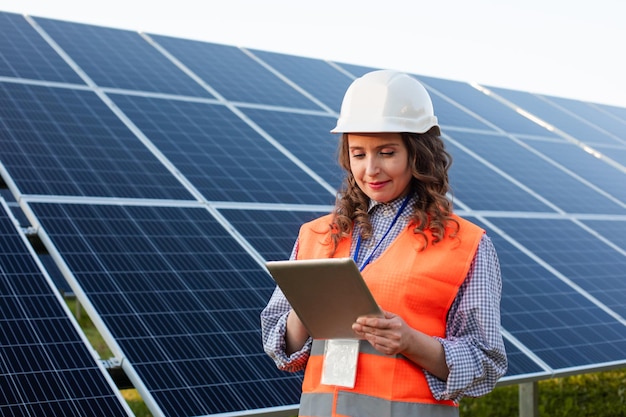 La ingeniera está trabajando con una tableta en una estación solar