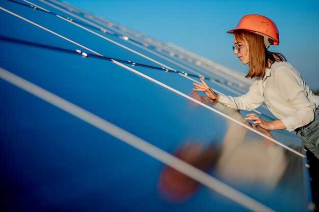 Ingeniera de pie cerca de paneles solares al aire libre