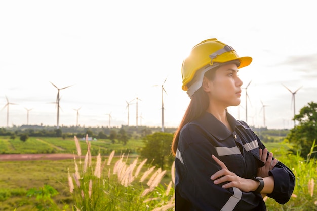 Una ingeniera se pone un casco protector en la cabeza al atardecer