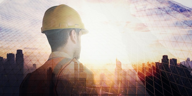 Ingeniería de construcción vida de la ciudad y concepto futuro imagen de doble exposición del ingeniero retrocediendo durante el amanecer superpuesto con imagen de paisaje urbano