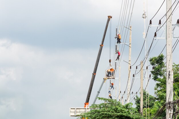 Foto ingeniería de hombres asiáticos trabajando en campo de trabajo de alta tensión en el campo