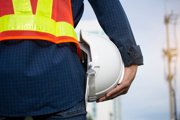Ingeniería tiene sombreros blancos de seguridad y poste eléctrico
