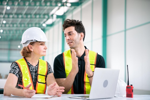 Foto el ingeniero de almacén trabaja en un cuaderno de tecnología con un empresario y un ingeniero gerente de negocios para el transporte de almacenamiento y entrega en la fábrica de la industria energética