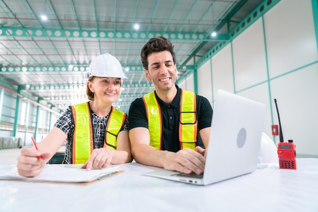 El ingeniero de almacén trabaja en un cuaderno de tecnología con un empresario y un ingeniero gerente de negocios para el transporte de almacenamiento y entrega en la fábrica de la industria energética