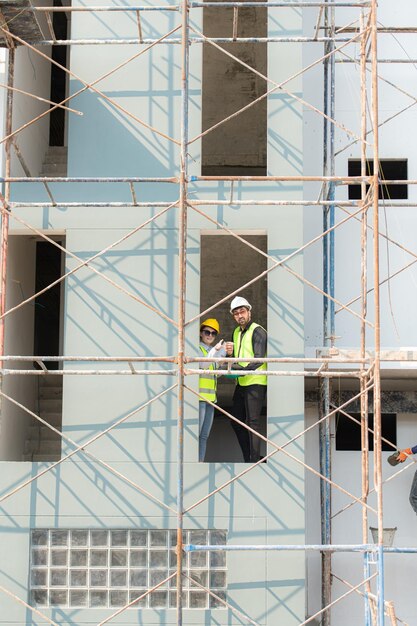 Foto ingeniero y arquitecto trabajando en el sitio de construcción revisando los planes y procesos