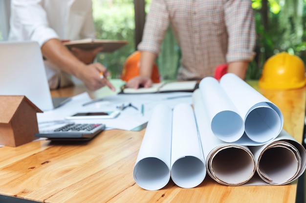 Ingeniero Arquitectos y equipo de oficina de agente de bienes raíces trabajando con planos