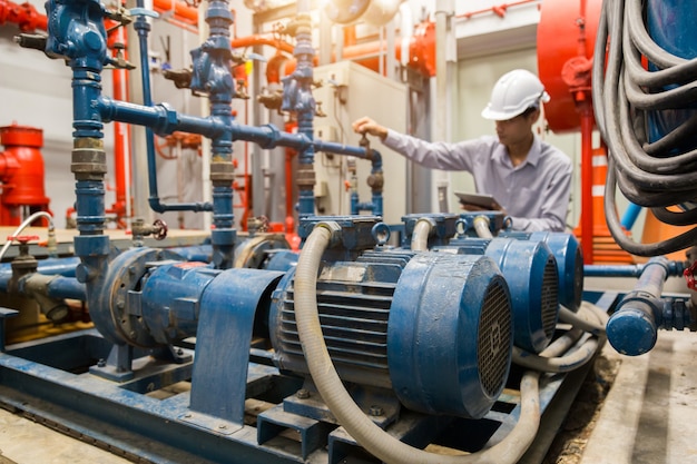 Ingeniero asiático, mantenimiento, verificación de datos técnicos del equipo del sistema Condensador Bomba de agua y manómetro, bomba de agua.