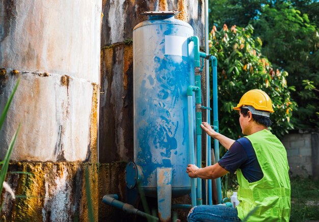 Foto ingeniero asiático que controla la calidad del agua en lugares que operan agua industrial