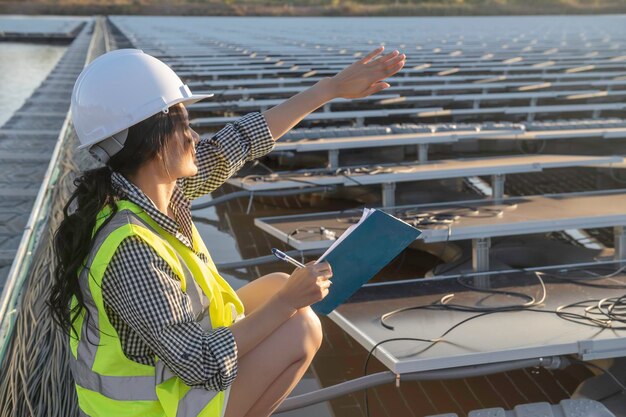 Ingeniero asiático trabajando en una granja solar flotanteEnergía renovableTécnico e inversor de paneles solares comprobando los paneles en la instalación de energía solar