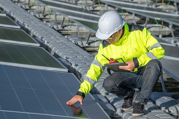 Ingeniero asiático trabajando en una planta de energía solar flotanteEnergía renovableTécnico e inversor de paneles solares comprobando los paneles en la instalación de energía solar