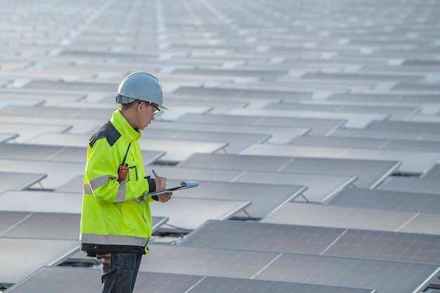 Ingeniero asiático trabajando en una planta de energía solar flotanteEnergía renovableTécnico e inversor de paneles solares comprobando los paneles en la instalación de energía solar