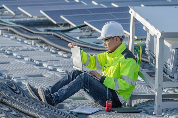 Ingeniero asiático trabajando en una planta de energía solar flotanteEnergía renovableTécnico e inversor de paneles solares comprobando los paneles en la instalación de energía solar