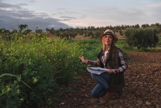 Ingeniero de campo femenino examinando plantación agrícola Integración agrónomo mujeres en el campo