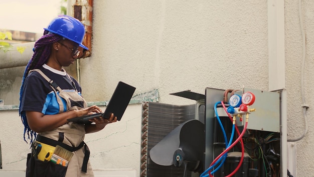 Ingeniero capacitado en el mantenimiento de las partes internas del aire acondicionado, comprobación del nivel de refrigerante y calibración de los termostatos. Técnico certificado que imputa los datos de los resultados de mantenimiento en la computadora portátil