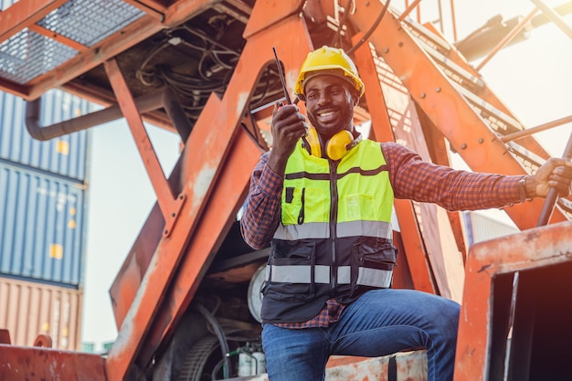 Ingeniero capataz feliz trabajando operar vehículo manipulador de contenedores en el patio de contenedores de carga del puerto para el envío de importación y exportación