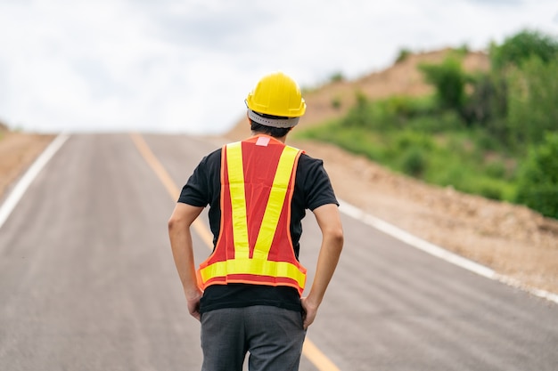 Ingeniero con casco amarillo por seguridad con la carretera