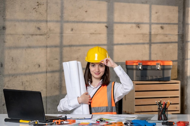 Foto ingeniero en casco y chaleco trabajador civil inteligente joven linda chica morena confiada