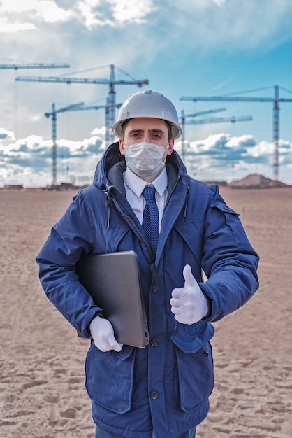 Ingeniero civil con casco blanco y chaqueta azul en el sitio