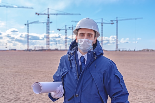 Ingeniero civil con casco blanco y chaqueta azul en el sitio