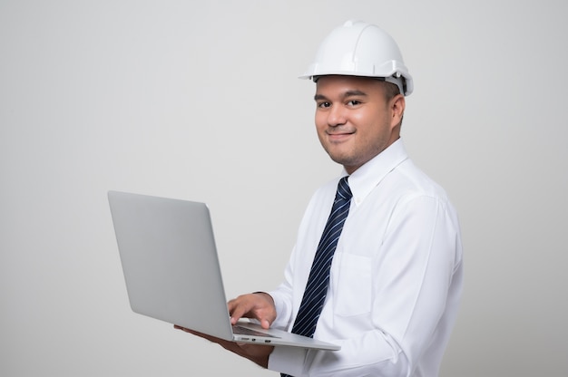 El ingeniero civil opera con una computadora portátil para controlar el trabajo en el estudio.