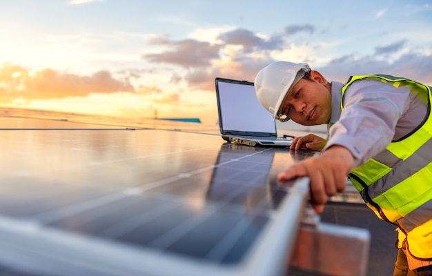 Foto el ingeniero está comprobando el sistema de la estación de energía fotovoltaica de células solares en la azotea.