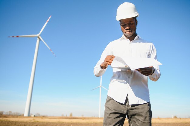 El ingeniero comprueba el sistema de turbina eólica con una tableta. Energía alternativa. Granja eólica. Tecnologías limpias de energías renovables. Plantas de energía eólica