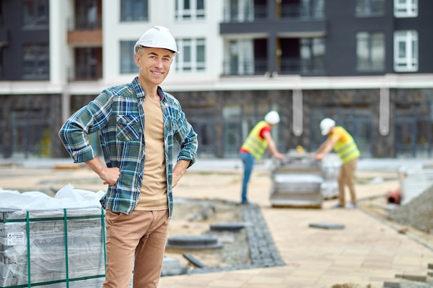 Ingeniero de construcción alegre en un casco mirando hacia el futuro