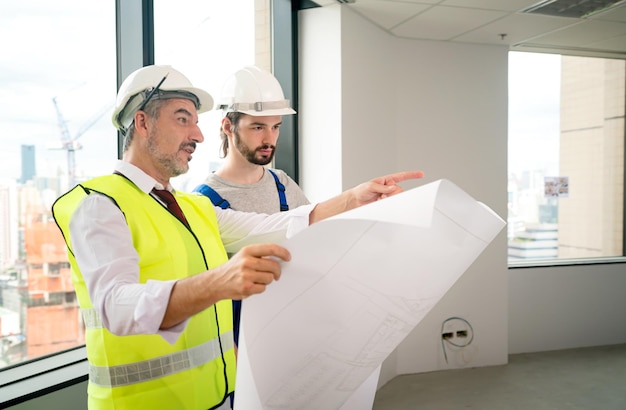 Ingeniero de construcción con capataz trabajador comprobando el sitio de construcción