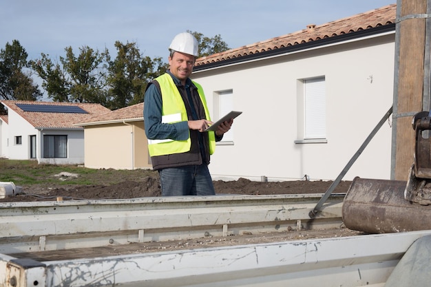 Ingeniero de construcción con tablet PC cerca del edificio