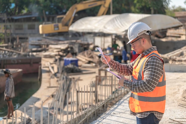 Ingeniero de construcción trabajando en un sitio de construcción de un puente sobre un río Ingeniero civil supervisando el trabajo Jefe de obra inspeccionando el trabajo en un lugar de construcción