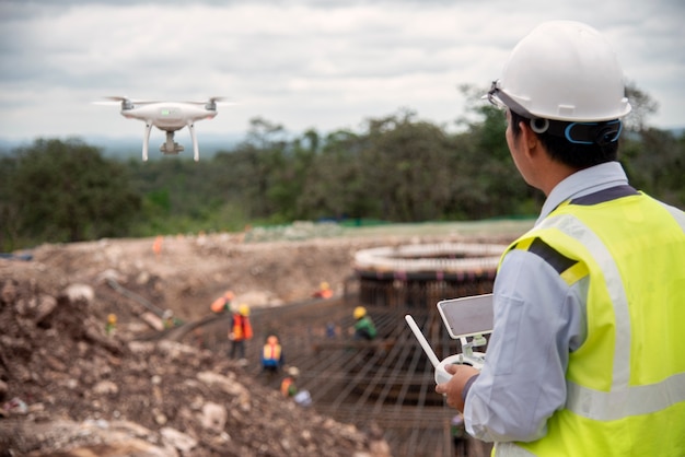 Ingeniero de construcción volar un avión no tripulado para tomar una foto para informe de progreso