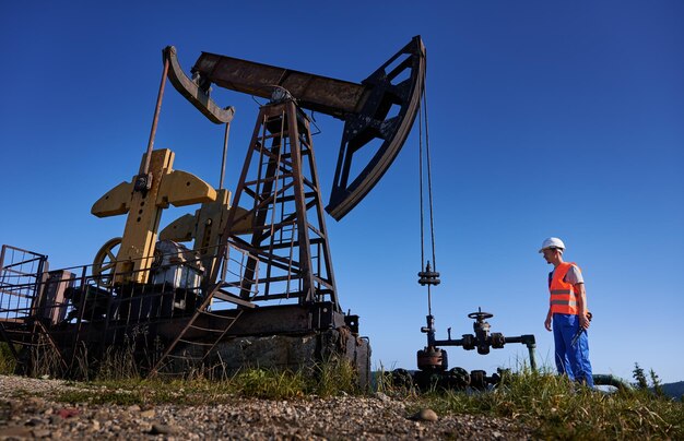 Ingeniero controlando la operación de una plataforma petrolera bajo un cielo azul