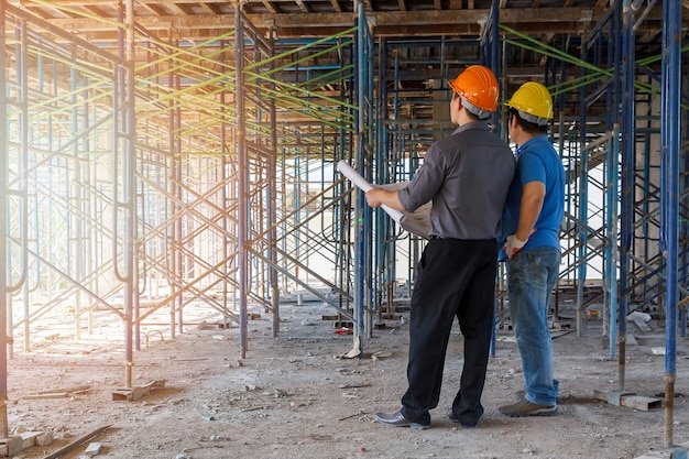 Ingeniero discutiendo con el capataz sobre el proyecto en el sitio de construcción de edificios