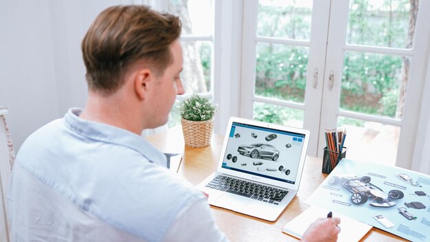Ingeniero de diseño de automóviles analiza el prototipo de automóvil para el negocio de automóviles en la oficina doméstica. El diseñador de ingeniería automotriz analiza cuidadosamente la búsqueda de fallas y mejoras para el diseño de automóviles con Synchronos portátiles.