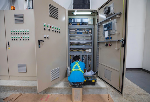 El ingeniero electricista prueba el control de la caja eléctrica