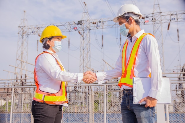 Ingeniero electricista de trabajo en equipo de pie en la planta de energía de la fábrica Concepto de ingeniero electricista de trabajo en equipo